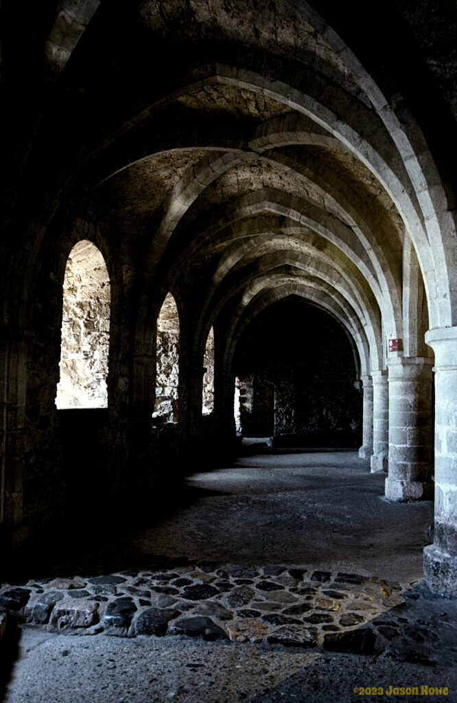vaulted archways leading into darkness beneath a medieval castle